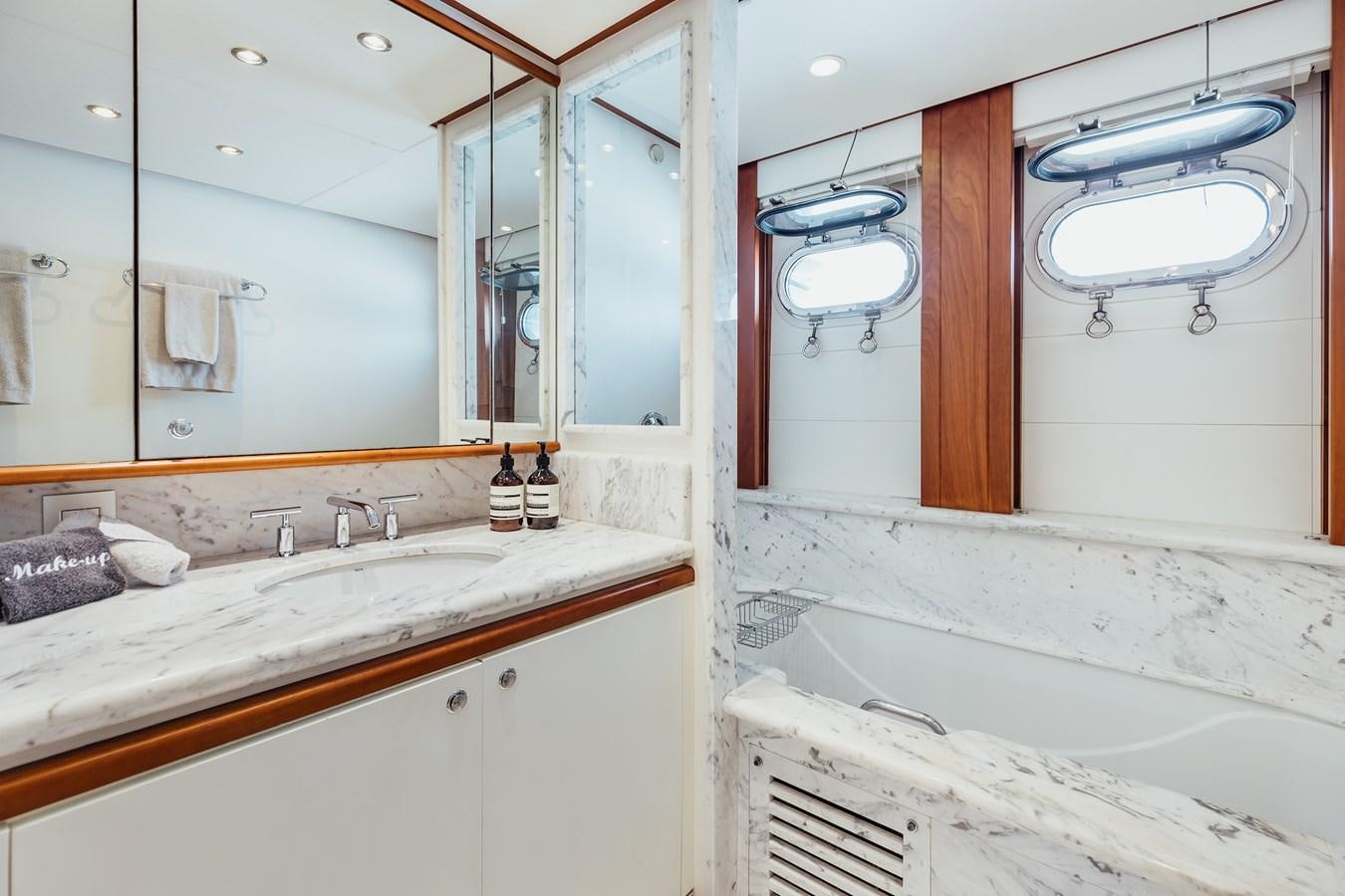 a bathroom with a tub sink and a mirror aboard ZULU Yacht for Sale