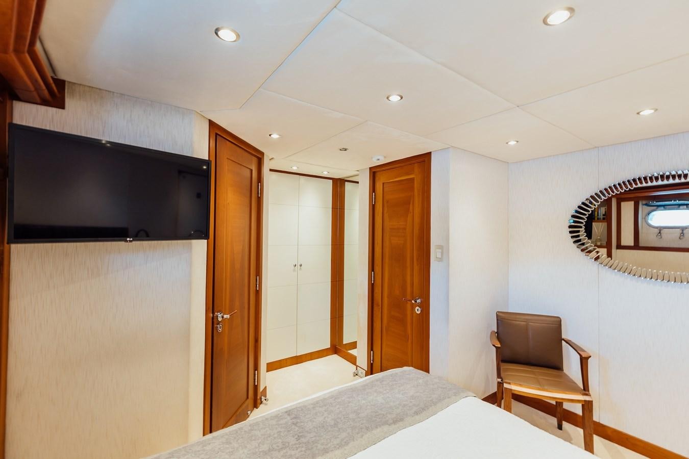 a bedroom with a bed and a tv on the wall aboard ZULU Yacht for Sale