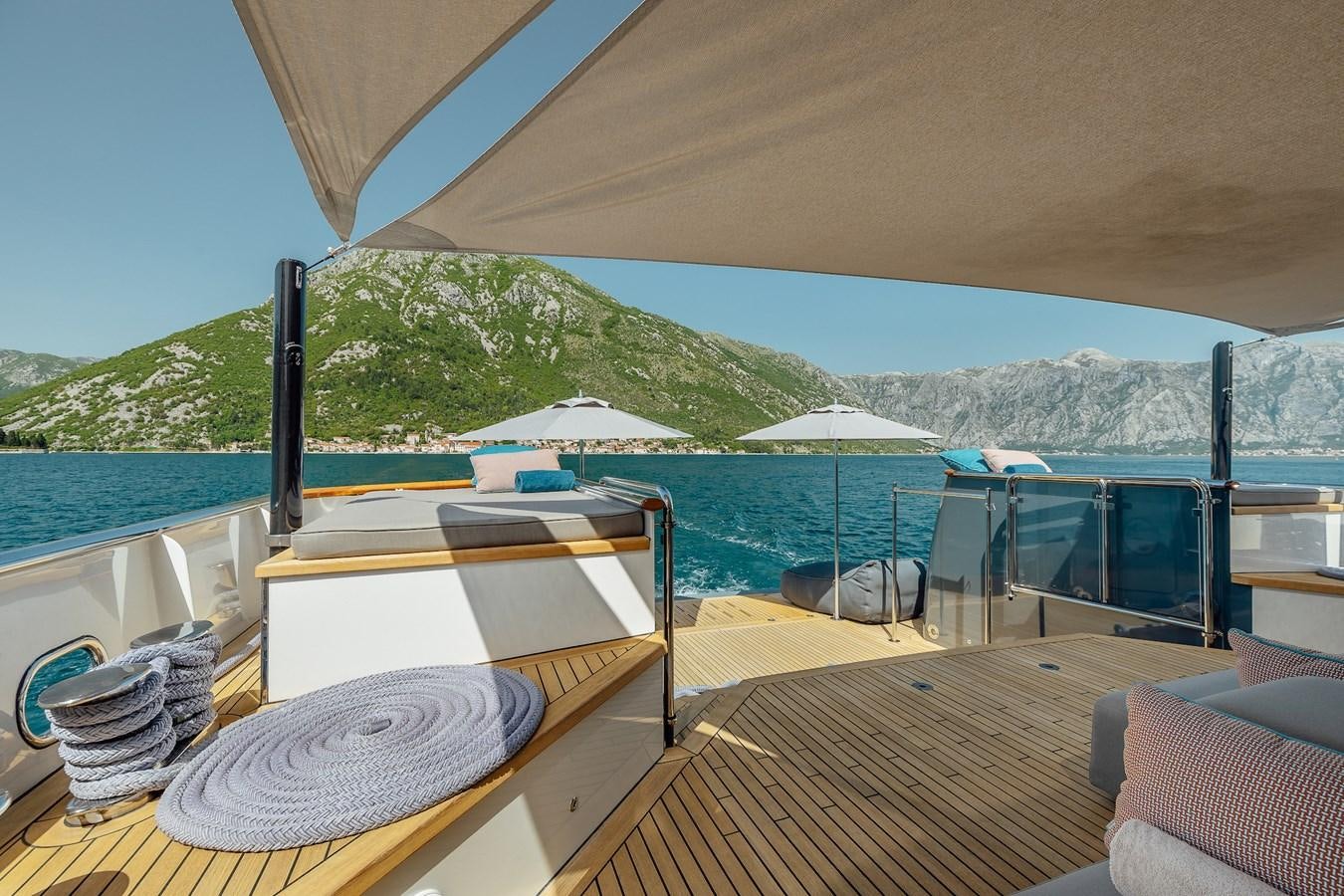 a deck with a view of the ocean and mountains aboard ZULU Yacht for Sale