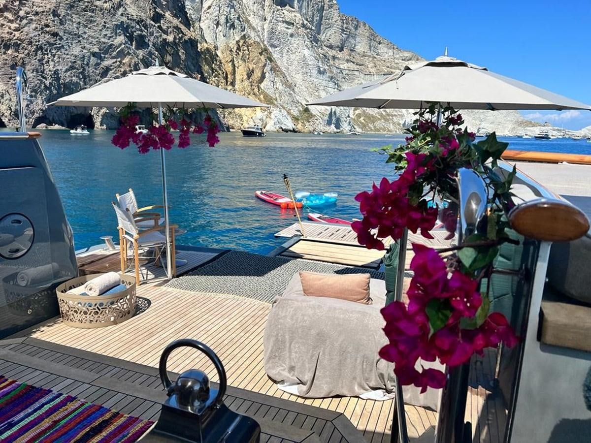 a table with a flower arrangement on it by a body of water aboard ZULU Yacht for Sale