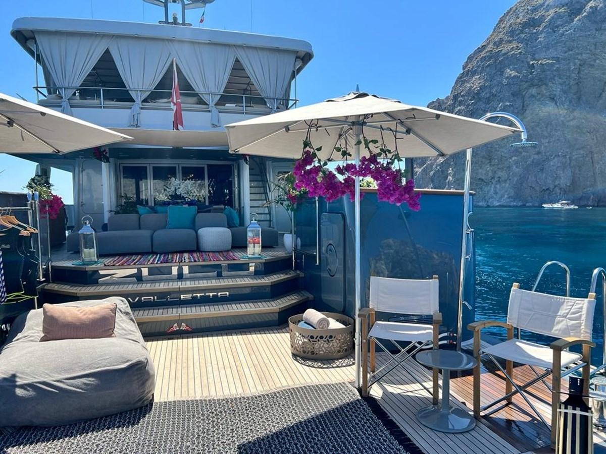 a deck with chairs and tables aboard ZULU Yacht for Sale