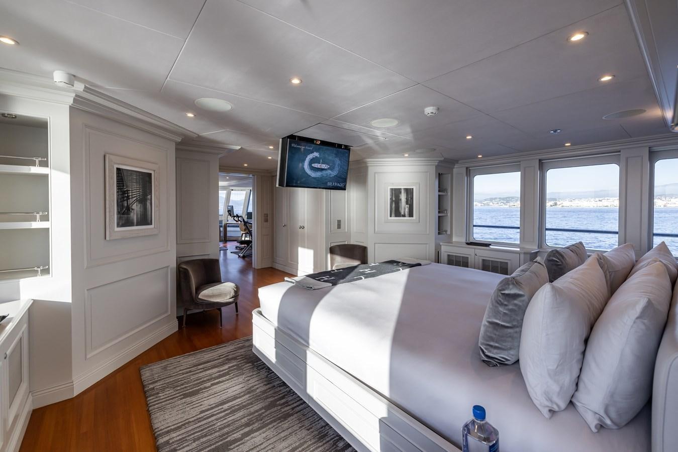 a large living room with a large bed and a tv on the wall aboard BRAVADO Yacht for Sale