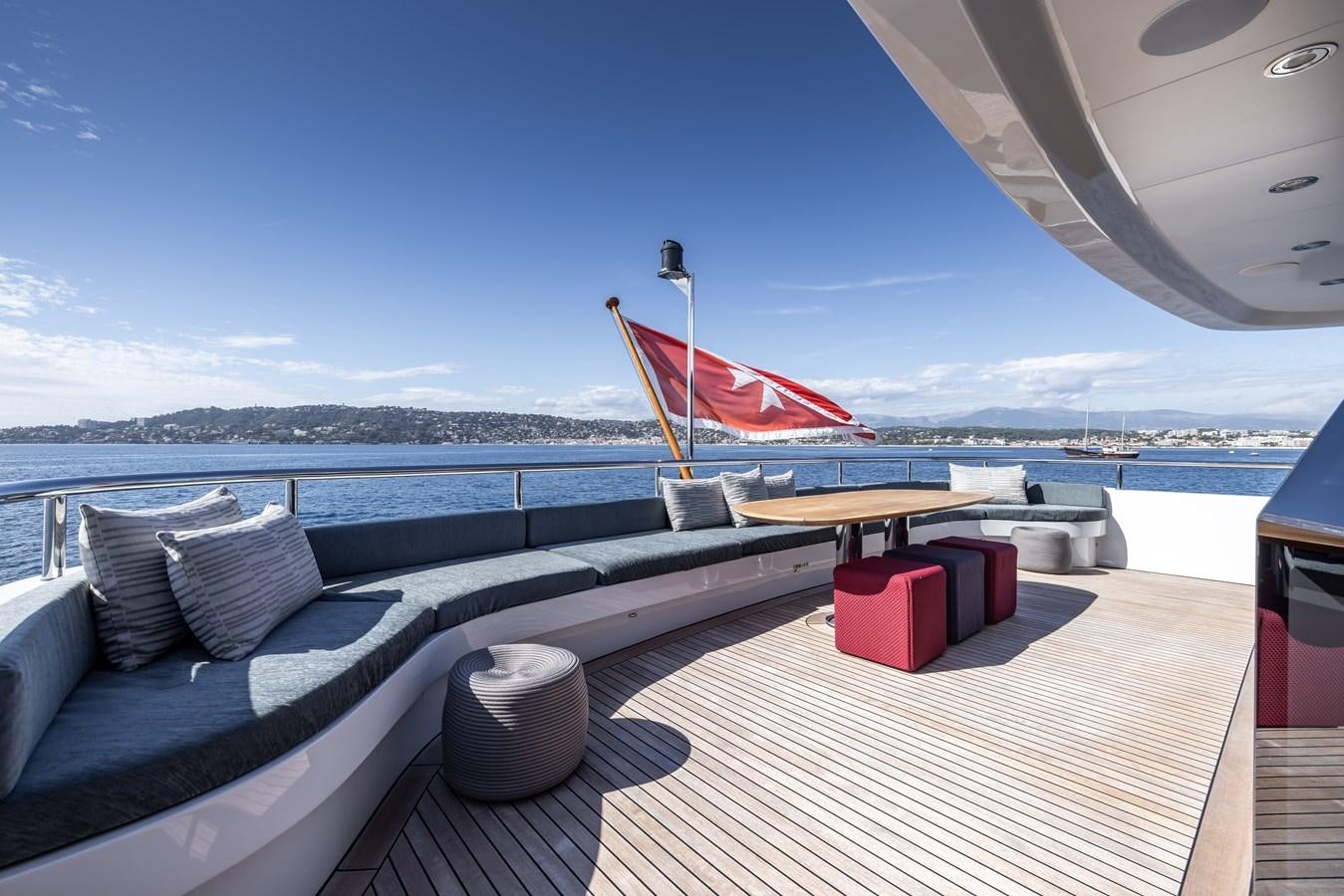 a deck with a large red and white umbrella on it aboard BRAVADO Yacht for Sale