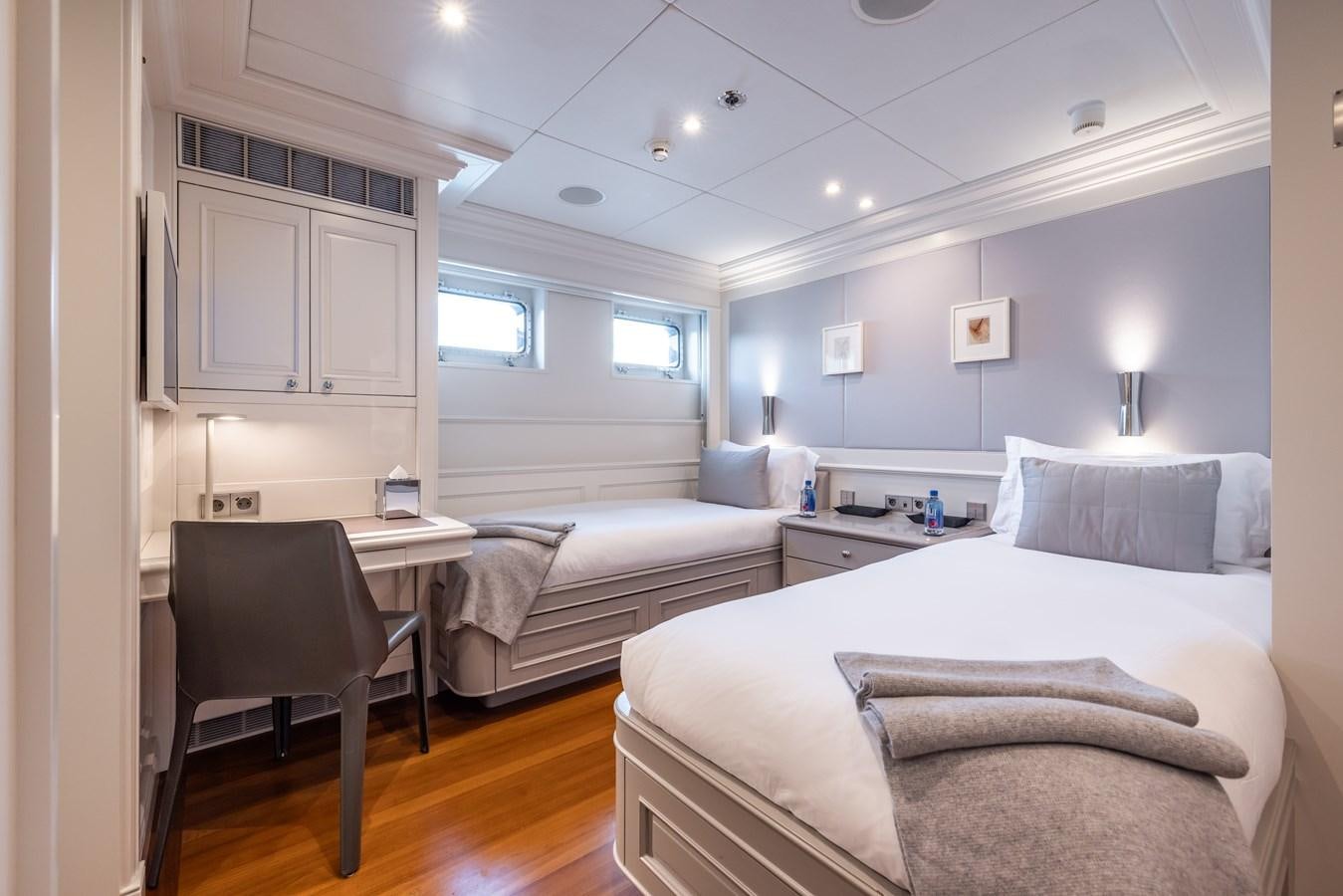 a bedroom with a bed and a desk aboard BRAVADO Yacht for Sale