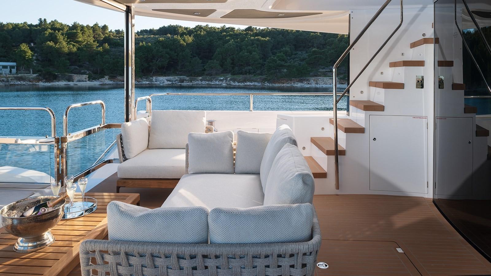 a room with a couch and a table and a view of a body of water aboard MOWANA Yacht for Sale