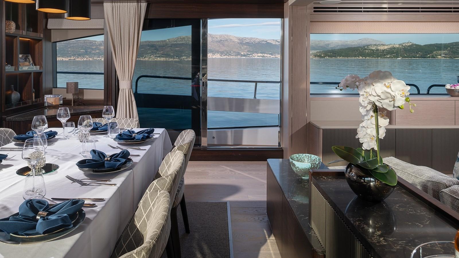 a table with plates and glasses on it aboard MOWANA Yacht for Sale