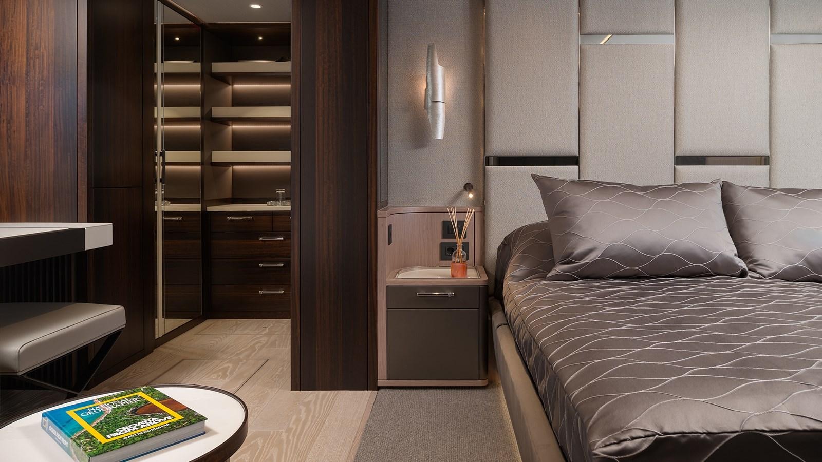 a bedroom with a bed and a bookcase aboard MOWANA Yacht for Sale