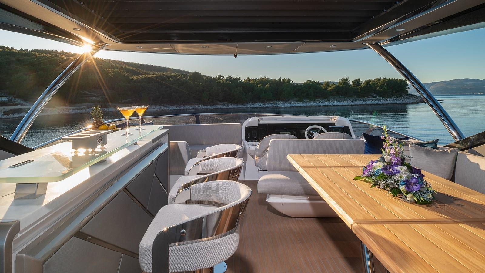 a table with chairs and a boat on it aboard MOWANA Yacht for Sale