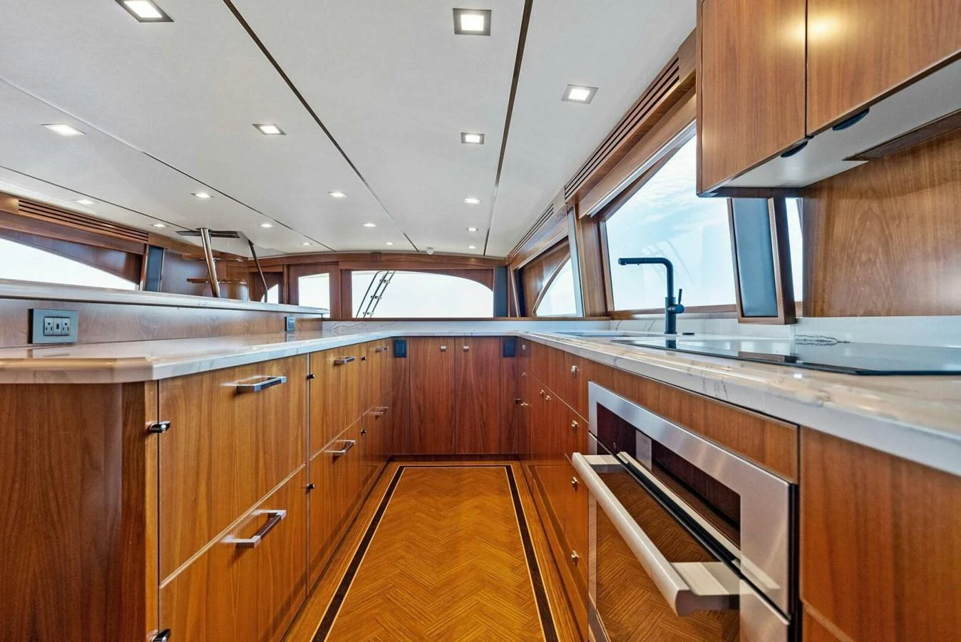a kitchen with wooden cabinets aboard TEAM MAYHEM Yacht for Sale