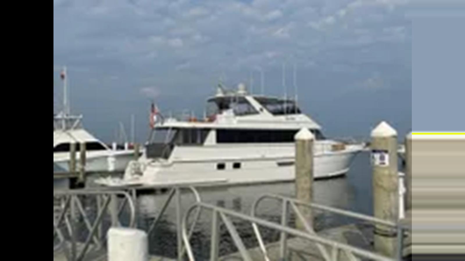a white boat docked aboard 1999 HATTERAS 74 SPORT DECK MOTOR YACHT Yacht for Sale