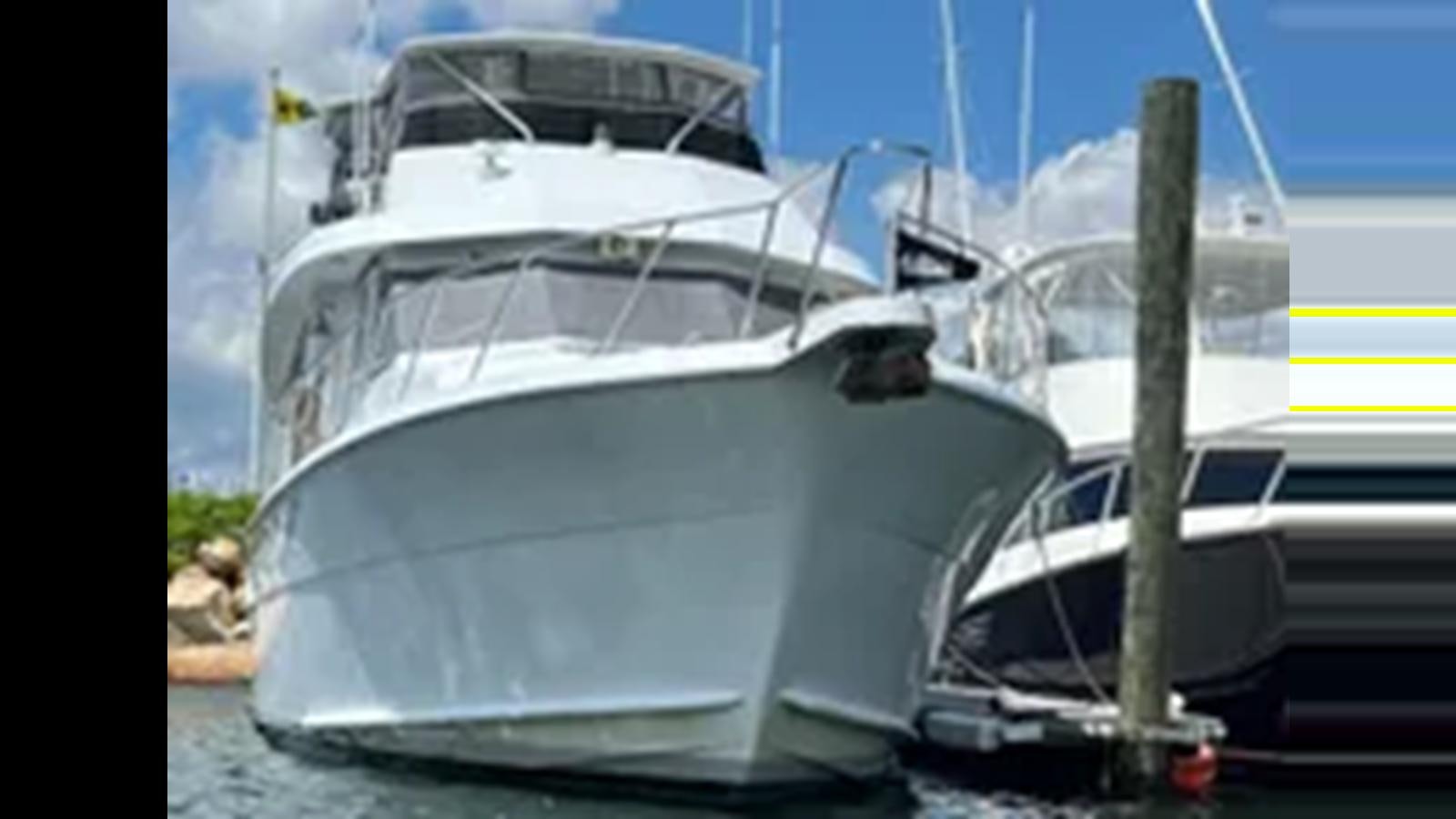 a white yacht parked on the beach aboard 1999 HATTERAS 74 SPORT DECK MOTOR YACHT Yacht for Sale
