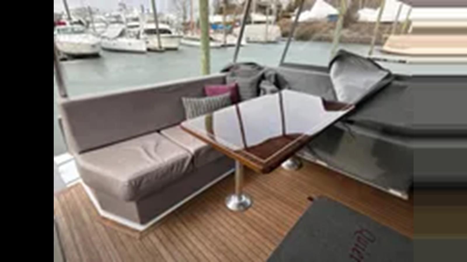 a table with a chair on it aboard 1999 HATTERAS 74 SPORT DECK MOTOR YACHT Yacht for Sale