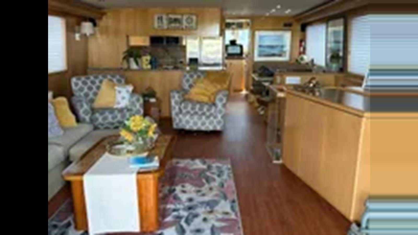 a living room with a couch and a table aboard 1999 HATTERAS 74 SPORT DECK MOTOR YACHT Yacht for Sale