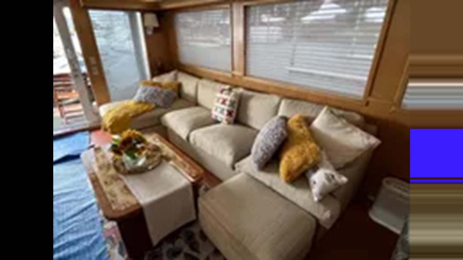 a living room with a couch and a table aboard 1999 HATTERAS 74 SPORT DECK MOTOR YACHT Yacht for Sale