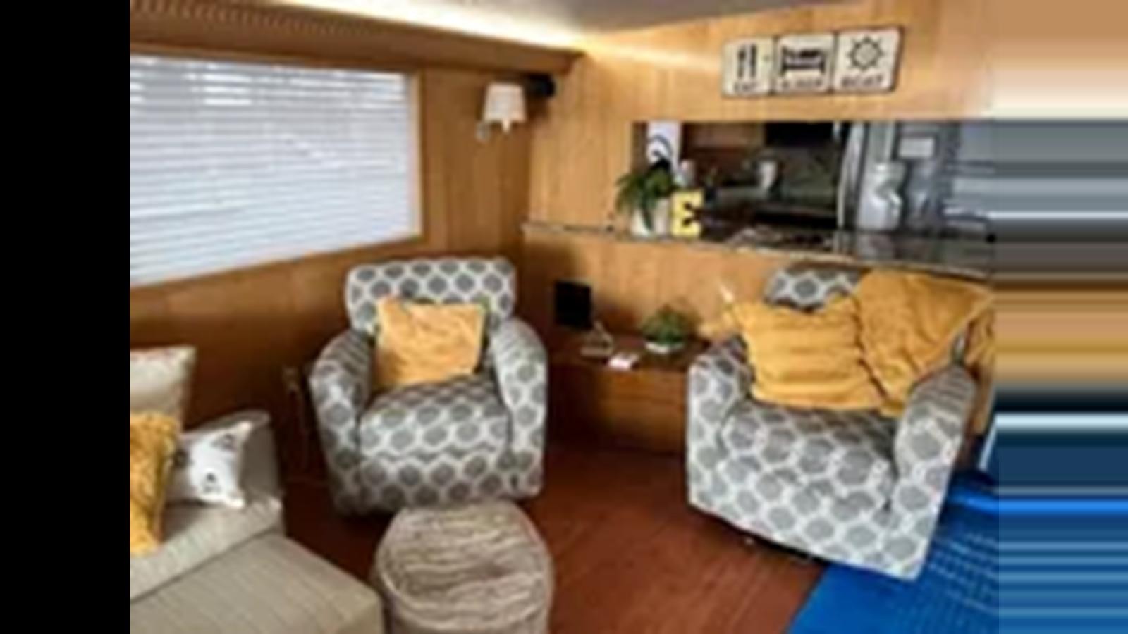 a living room with a couch and chairs aboard 1999 HATTERAS 74 SPORT DECK MOTOR YACHT Yacht for Sale