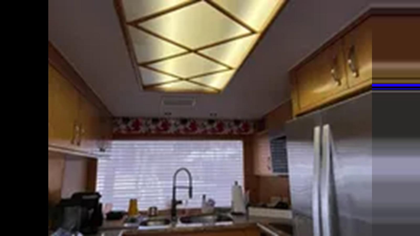a kitchen with a fridge and a sink aboard 1999 HATTERAS 74 SPORT DECK MOTOR YACHT Yacht for Sale