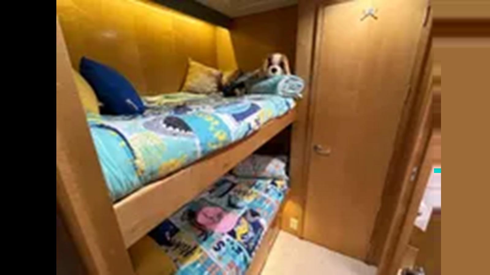 a bed with a blue and white blanket and a blue pillow aboard 1999 HATTERAS 74 SPORT DECK MOTOR YACHT Yacht for Sale