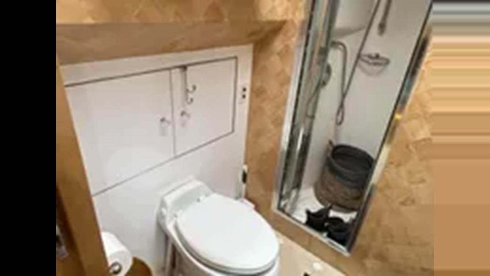 a toilet with a bucket on the tank aboard 1999 HATTERAS 74 SPORT DECK MOTOR YACHT Yacht for Sale
