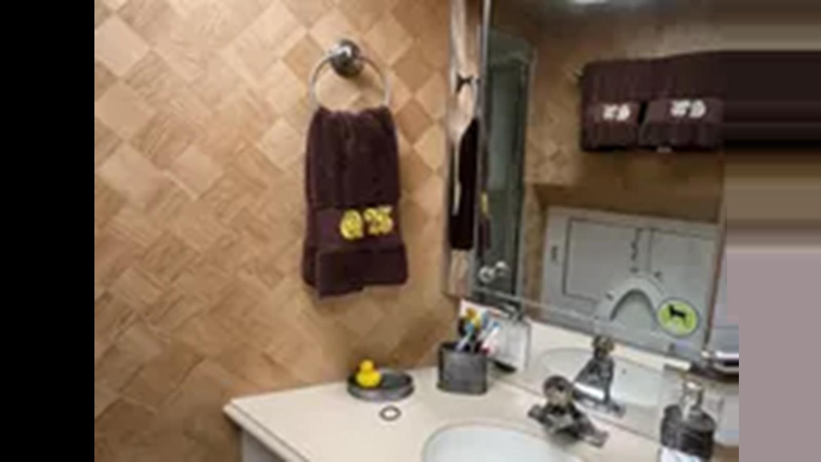 a bathroom with a mirror and a sink aboard 1999 HATTERAS 74 SPORT DECK MOTOR YACHT Yacht for Sale