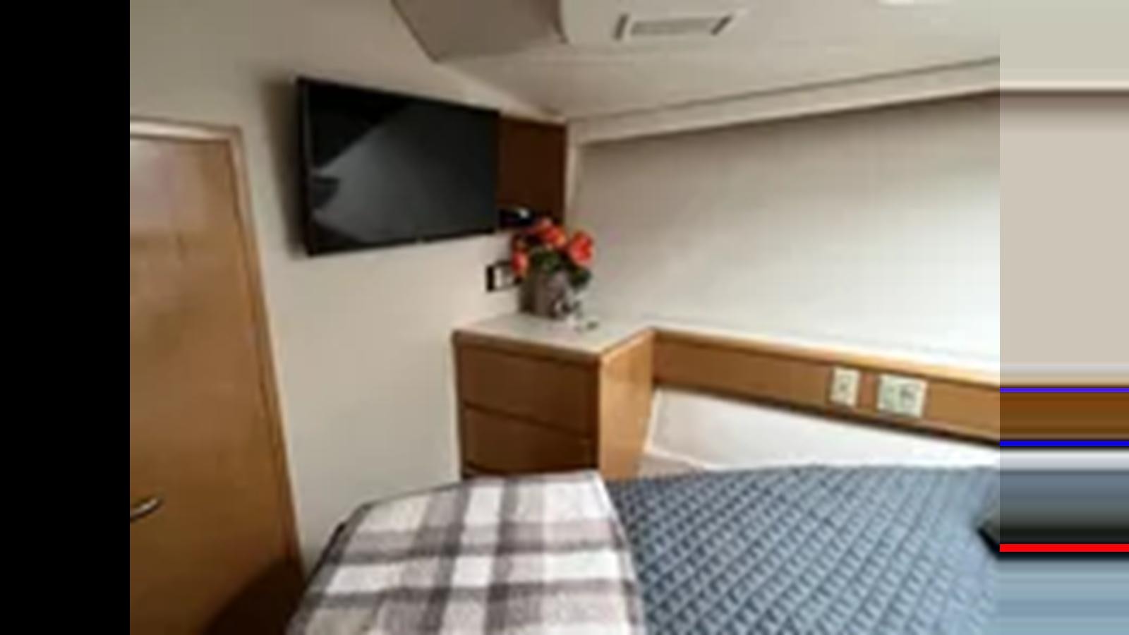 a room with a television and a bed aboard 1999 HATTERAS 74 SPORT DECK MOTOR YACHT Yacht for Sale