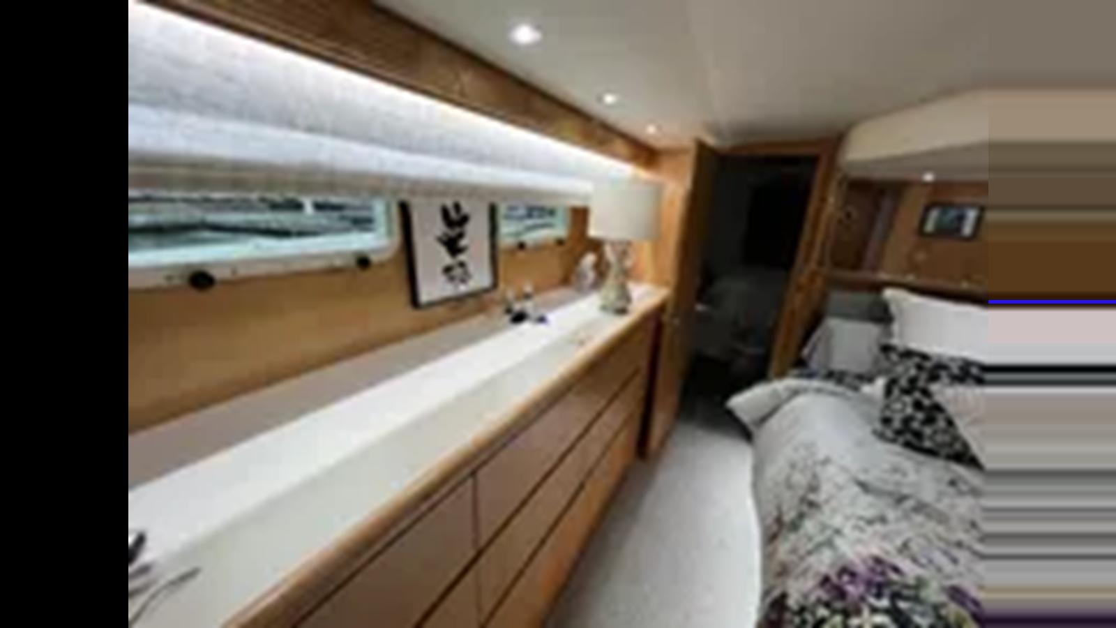 a room with a bed and a desk aboard 1999 HATTERAS 74 SPORT DECK MOTOR YACHT Yacht for Sale