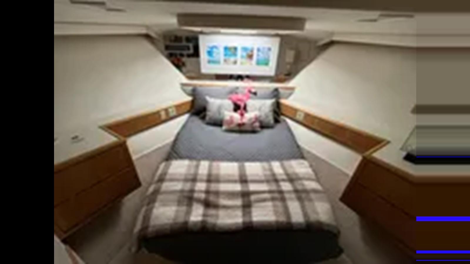 a bed with a television on top of it aboard 1999 HATTERAS 74 SPORT DECK MOTOR YACHT Yacht for Sale