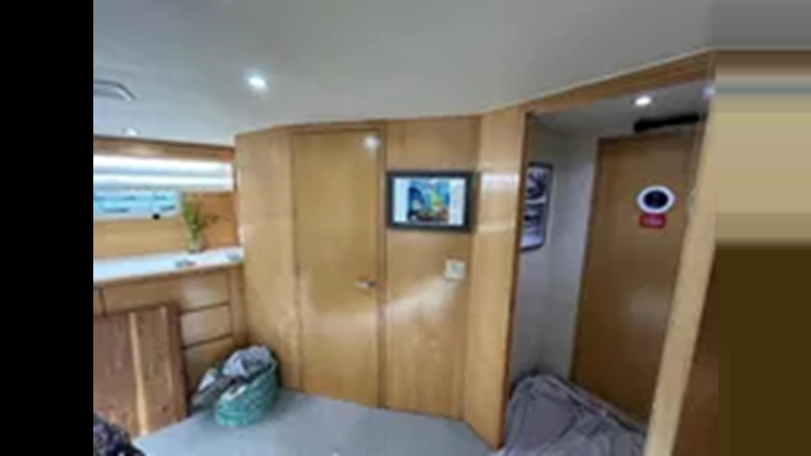 a room with a bed and a television aboard 1999 HATTERAS 74 SPORT DECK MOTOR YACHT Yacht for Sale