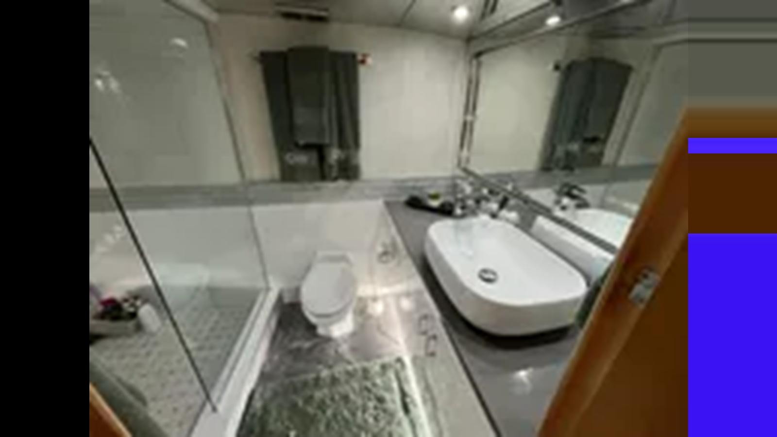 a bathroom with a sink and a mirror aboard 1999 HATTERAS 74 SPORT DECK MOTOR YACHT Yacht for Sale