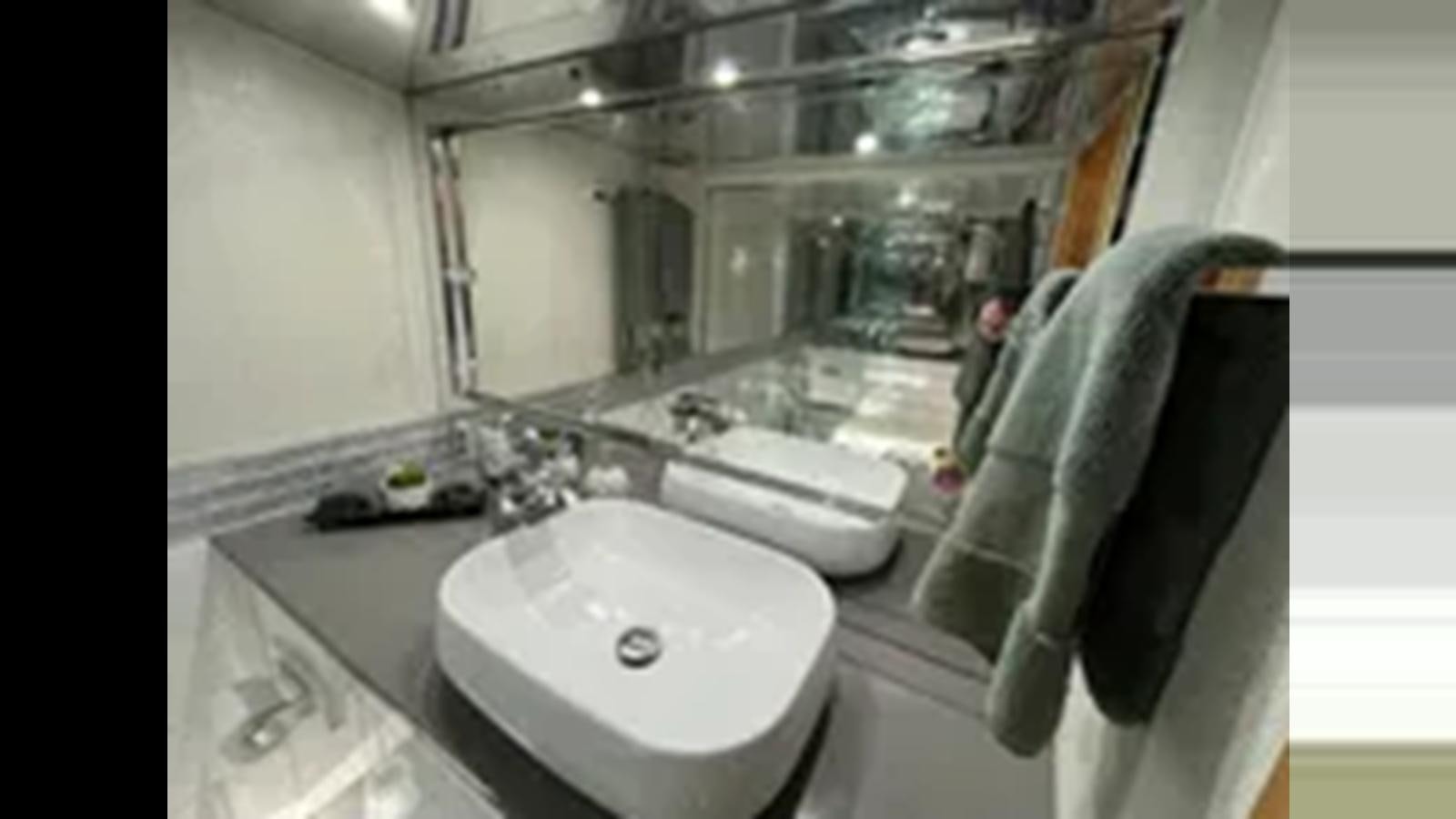 a person taking a picture of a bathroom sink aboard 1999 HATTERAS 74 SPORT DECK MOTOR YACHT Yacht for Sale