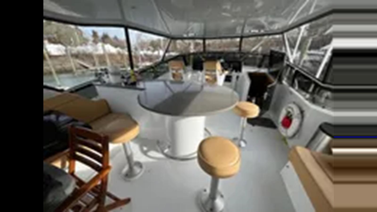 a room with chairs and tables aboard 1999 HATTERAS 74 SPORT DECK MOTOR YACHT Yacht for Sale