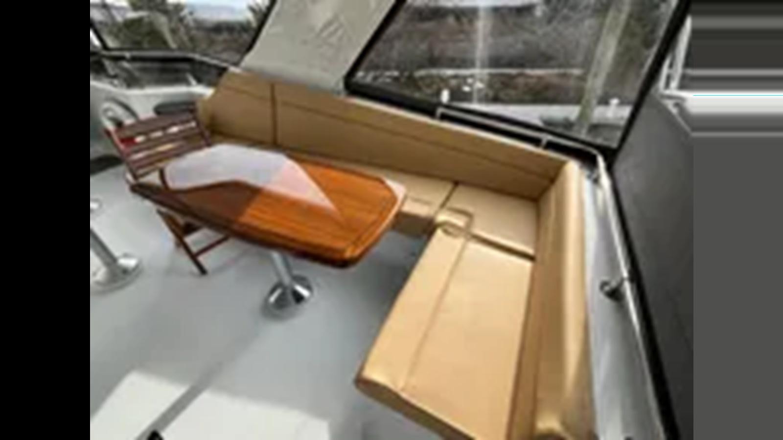 a wooden chair on a table aboard 1999 HATTERAS 74 SPORT DECK MOTOR YACHT Yacht for Sale