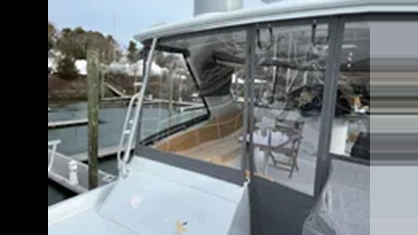 a window with a view of trees and a body of water aboard 1999 HATTERAS 74 SPORT DECK MOTOR YACHT Yacht for Sale