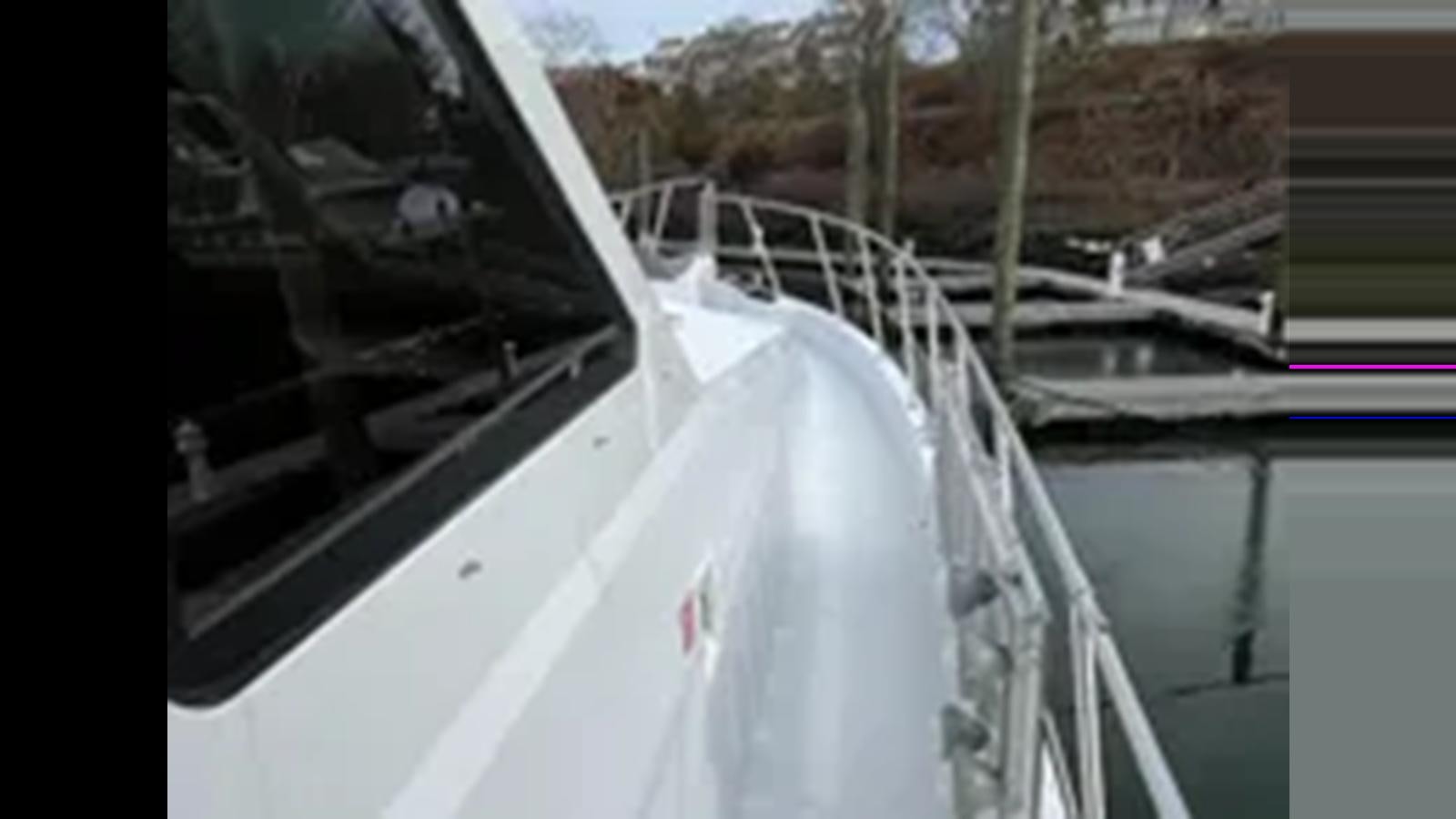 a white boat on a river aboard 1999 HATTERAS 74 SPORT DECK MOTOR YACHT Yacht for Sale