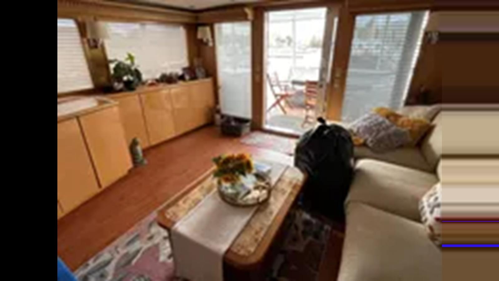 a living room with a couch and a table aboard 1999 HATTERAS 74 SPORT DECK MOTOR YACHT Yacht for Sale