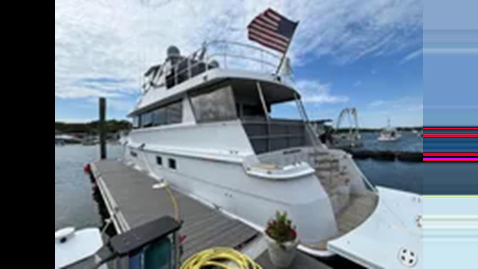 a boat docked at a pier aboard 1999 HATTERAS 74 SPORT DECK MOTOR YACHT Yacht for Sale
