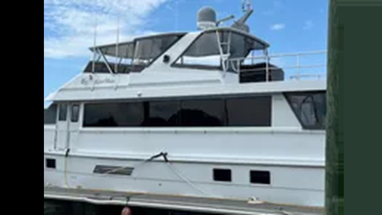 a white yacht on a dock aboard 1999 HATTERAS 74 SPORT DECK MOTOR YACHT Yacht for Sale
