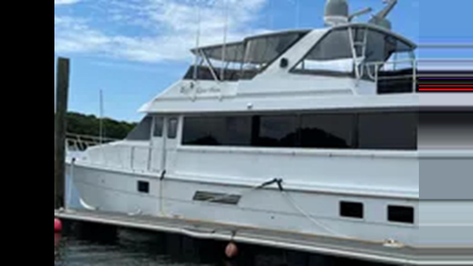 a white yacht on a dock aboard 1999 HATTERAS 74 SPORT DECK MOTOR YACHT Yacht for Sale