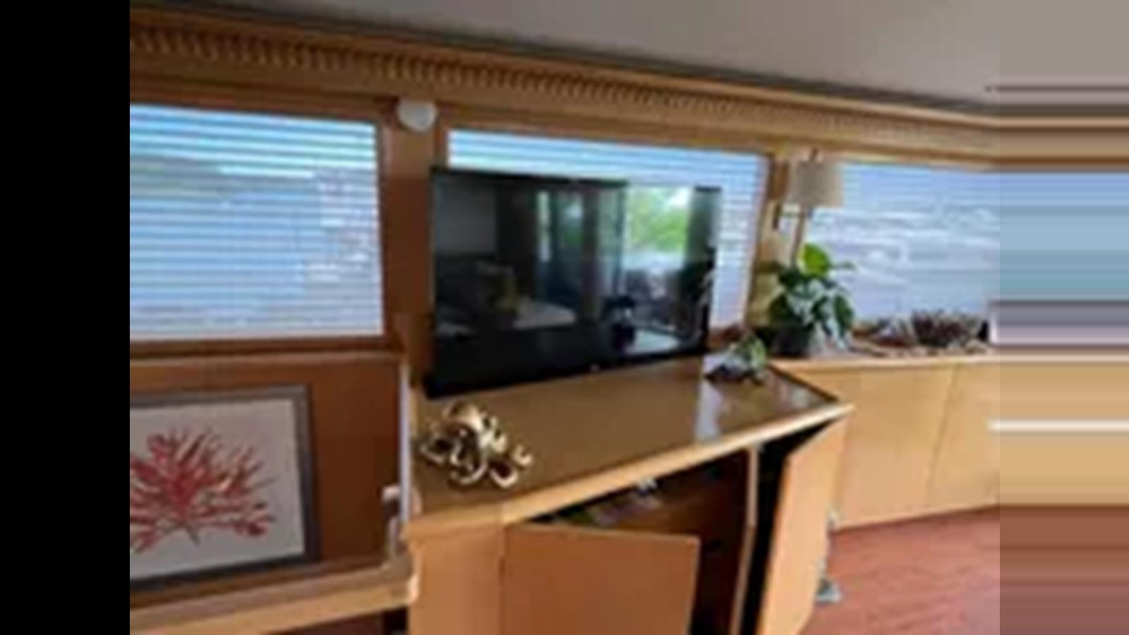 a room with a desk and a television aboard 1999 HATTERAS 74 SPORT DECK MOTOR YACHT Yacht for Sale