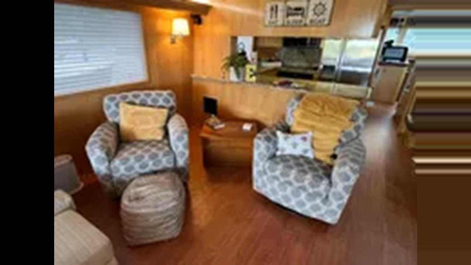 a room with a couch and a chair aboard 1999 HATTERAS 74 SPORT DECK MOTOR YACHT Yacht for Sale