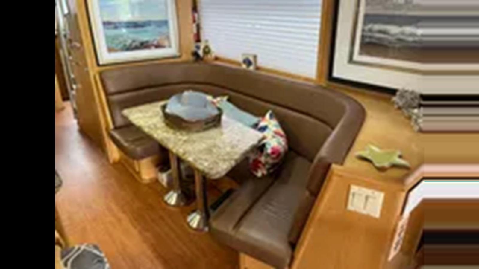 a table with a hat on it aboard 1999 HATTERAS 74 SPORT DECK MOTOR YACHT Yacht for Sale