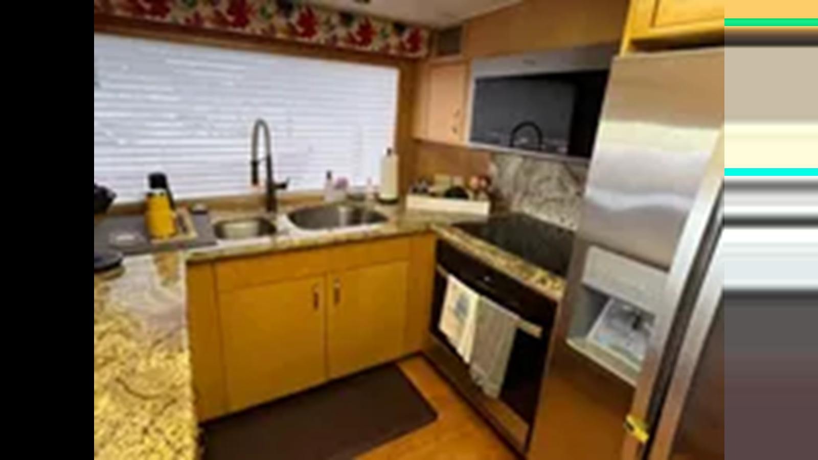 a kitchen with a sink and cabinets aboard 1999 HATTERAS 74 SPORT DECK MOTOR YACHT Yacht for Sale