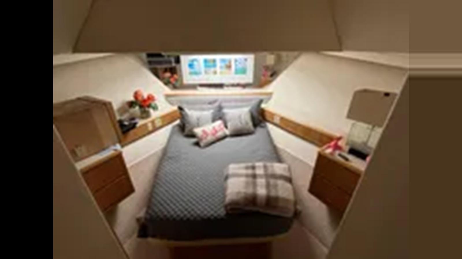 a small bedroom with a bed aboard 1999 HATTERAS 74 SPORT DECK MOTOR YACHT Yacht for Sale