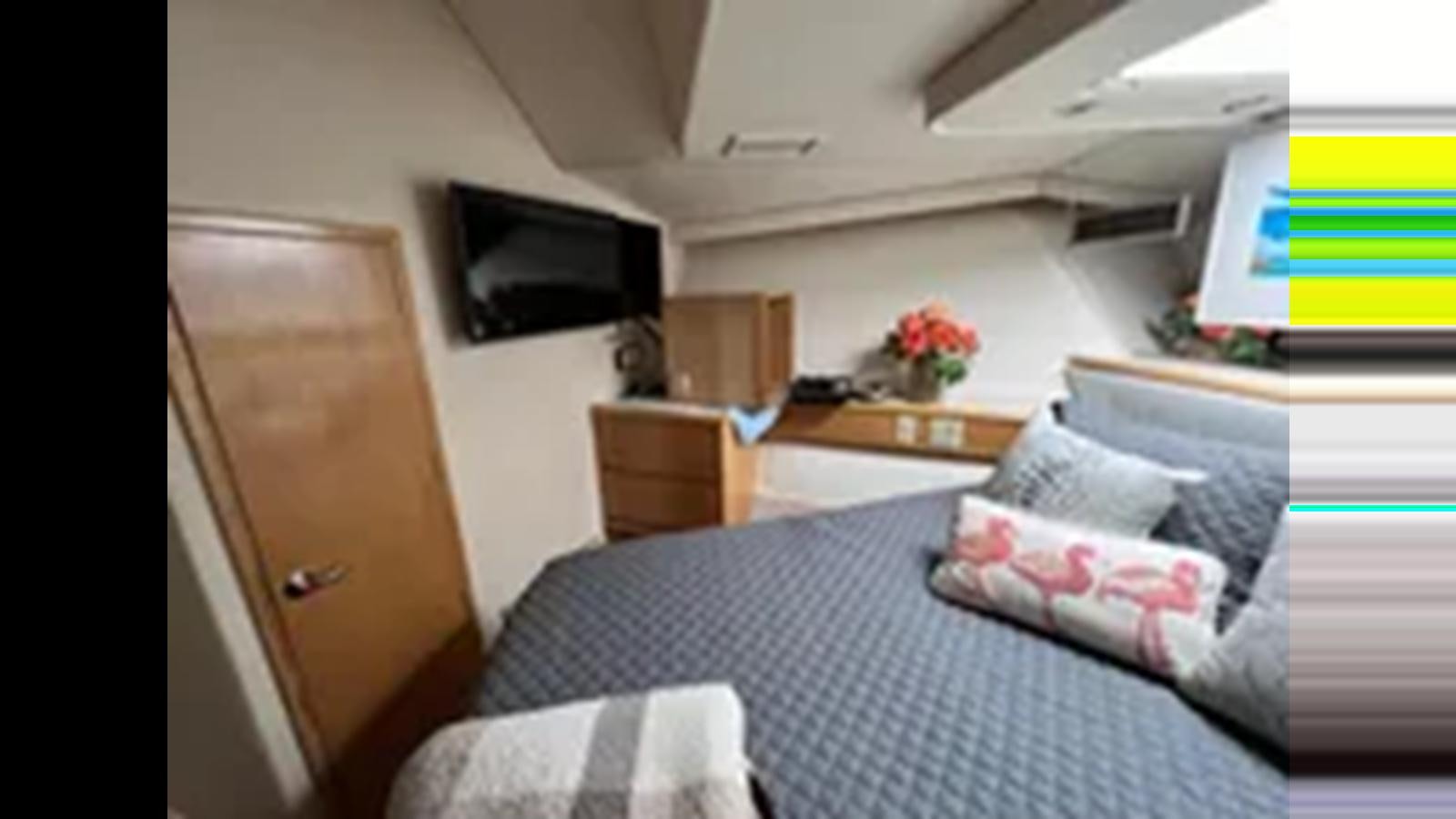 a bedroom with a bed and a tv aboard 1999 HATTERAS 74 SPORT DECK MOTOR YACHT Yacht for Sale