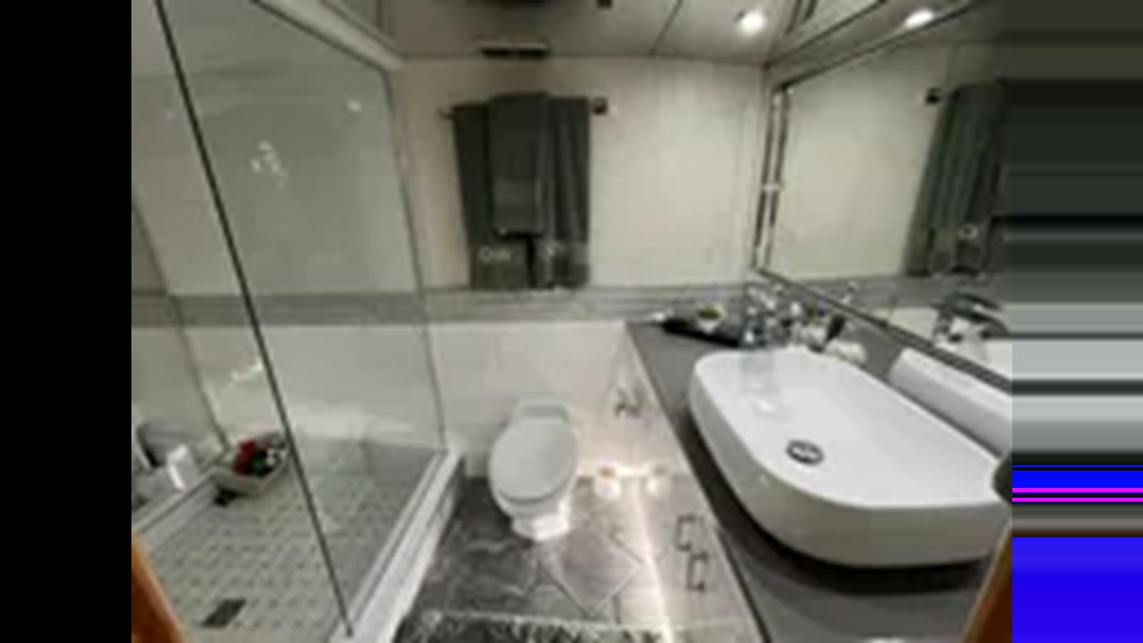 a bathroom with a sink and a mirror aboard 1999 HATTERAS 74 SPORT DECK MOTOR YACHT Yacht for Sale