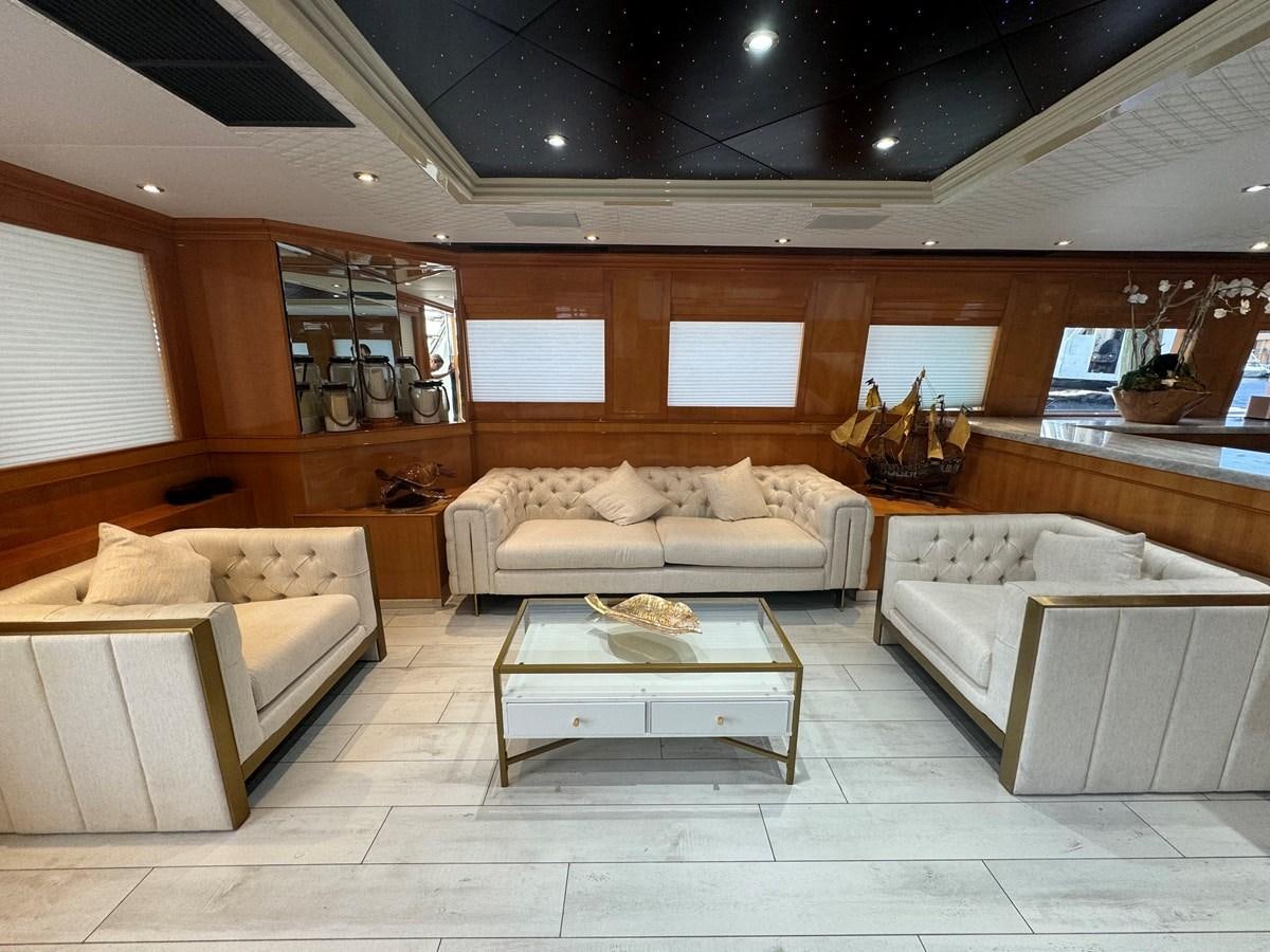 a living room with a table and couches aboard BAGLIETTO 116 Yacht for Sale