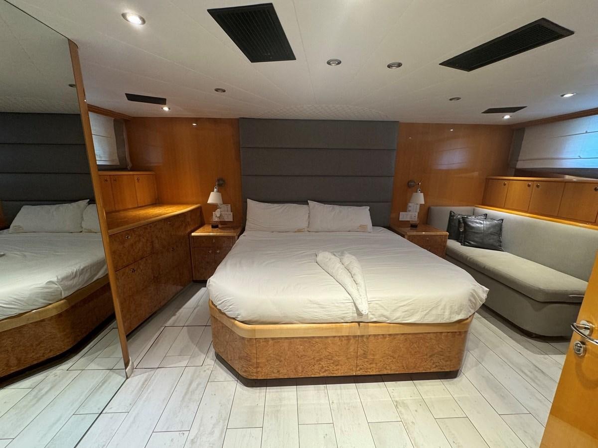 a room with a bed and a desk aboard BAGLIETTO 116 Yacht for Sale