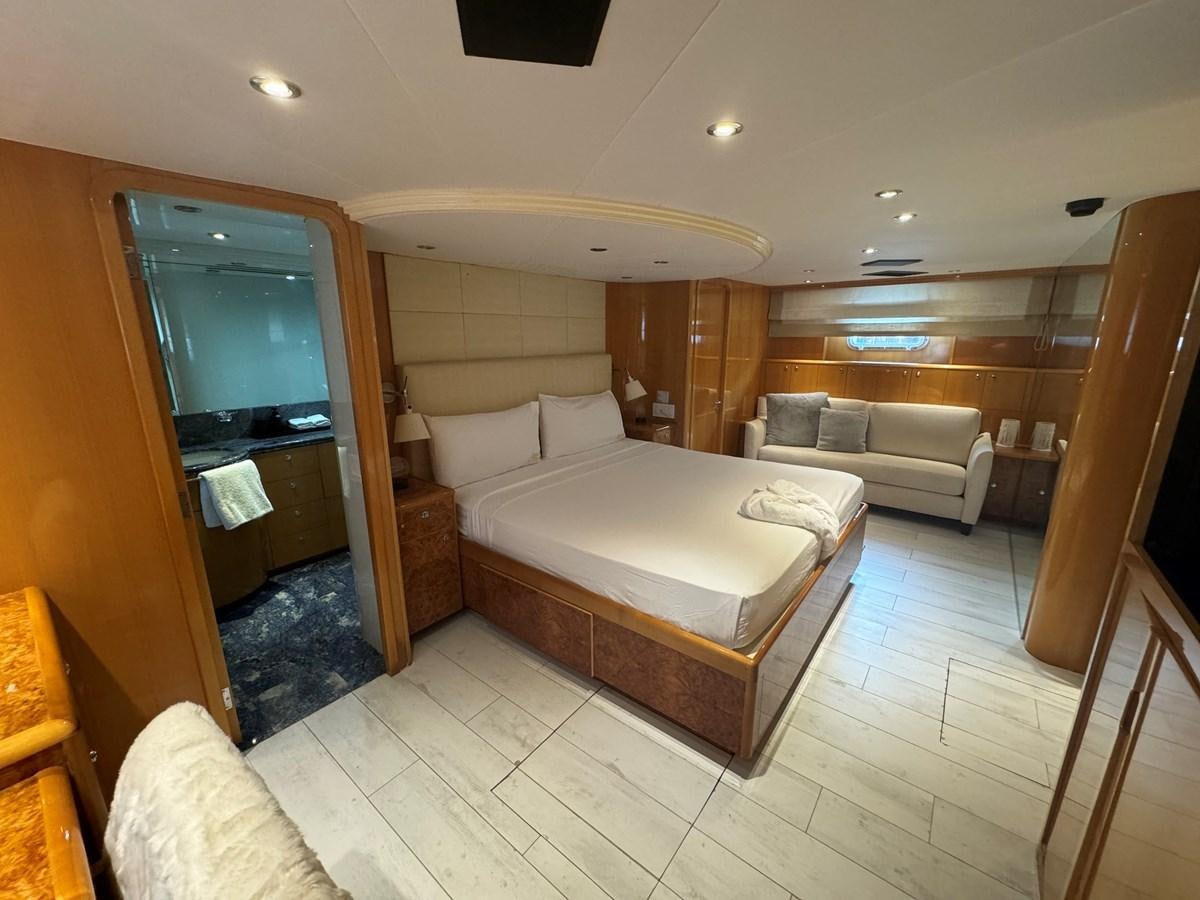 a bedroom with a bed and a couch aboard BAGLIETTO 116 Yacht for Sale