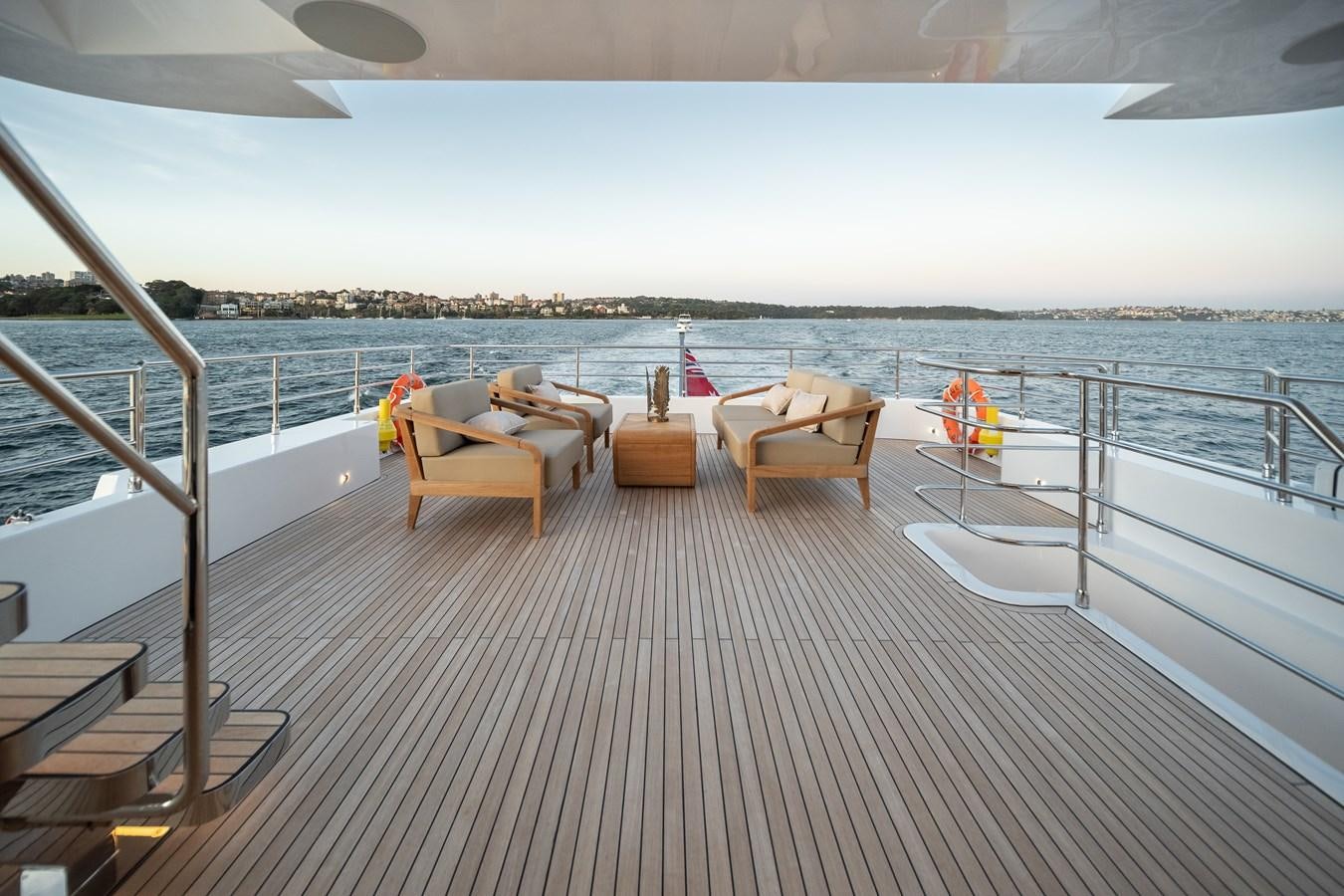 a deck with chairs and a body of water aboard BLUESTONE Yacht for Sale