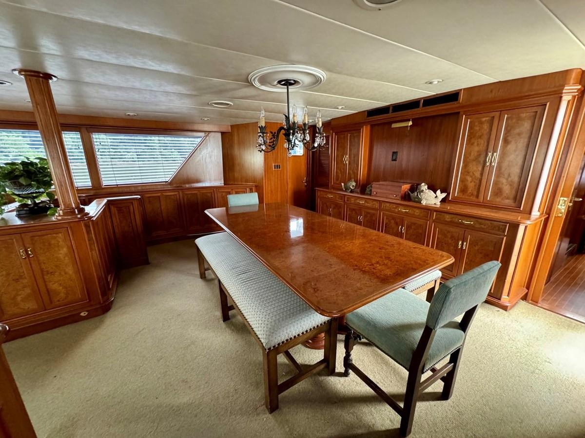 a dining table and chairs in a room aboard BRAVEHEART Yacht for Sale