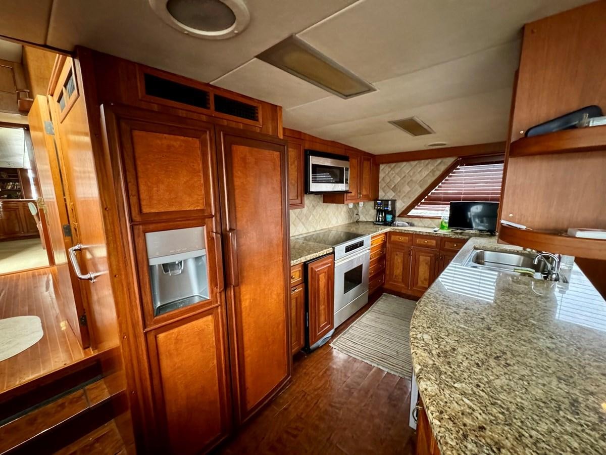 a kitchen with wooden cabinets aboard BRAVEHEART Yacht for Sale
